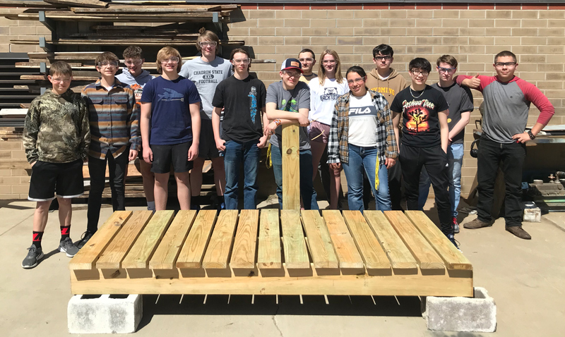 Students from the Sheridan High School Woods I class with a bridge the class designed, built and installed at Hidden Hoot Trail